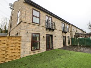 een groot bakstenen huis met een tuin ervoor bij The House at The Sitwell Arms in Sheffield