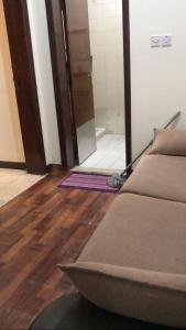 a room with a couch and wooden floors and a bathroom at NuZee Hostel for Girls only in Dubai