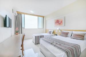 a hotel room with two beds and a tv at Hotel Nacional Inn Piracicaba in Piracicaba