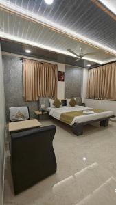 a bedroom with a large bed and a desk at Cool Palace Hotels in Nashik