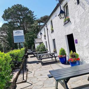 a group of benches sitting outside of a building at The Glenbeigh Hotel in Glenbeigh