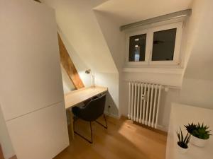 Habitación pequeña con escritorio y ventana. en Les toits de Gutenberg, en Estrasburgo
