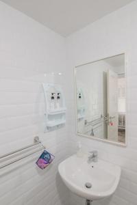 a white bathroom with a sink and a mirror at Harvest Mountain Farm Guesthouse in Bogor