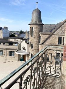 a balcony with a metal railing and a building at La Belle Consigne - Appartements Dinan Centre Gare in Dinan