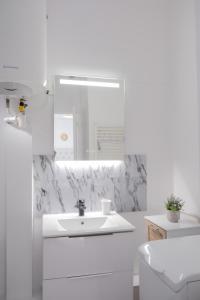 a white bathroom with a sink and a mirror at Résidence Peace in Le Bourget +66 photos