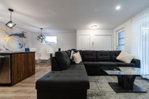 ein Wohnzimmer mit schwarzem Sofa und einem Tisch in der Unterkunft Appartement cosy à Beauport in Québec