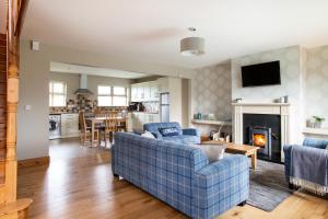 a living room with a blue couch and a fireplace at Donegal Boardwalk Resort in Carrigart