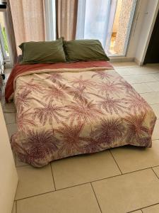 1 cama con edredón en el suelo de un dormitorio en Studio 200m de la plage Le Barcares en Le Barcarès