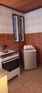 uma cozinha com fogão, mesa e janela em Casa com ar condicionado em Lauro de Freitas