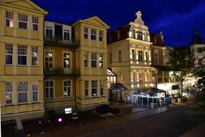 un grupo de edificios en una calle por la noche en Hotel Meereseck, en Bansin