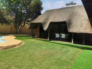 a hut with two tables and a grass yard at Exclusive Private Room in Joburg No loadshedding in Johannesburg