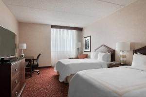 a hotel room with two beds and a flat screen tv at Columbus Airport Marriott in Columbus +31 photos