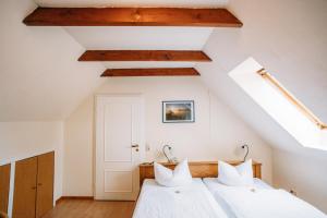 Schlafzimmer im Dachgeschoss mit einem Bett mit weißer Bettwäsche in der Unterkunft Hotel Zum König von Griechenland in Ovelgönne
