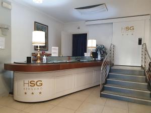 a hotel lobby with a reception desk and stairs at Hotel San Giorgio in Bergamo