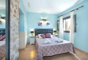 Dormitorio azul con cama y ventana en Owl Booking Villa Maria - Family and Friends en El Port