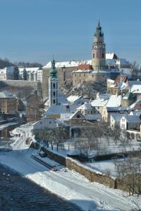 a city with snow and buildings and two towers at Hotel Leonardo in Český Krumlov