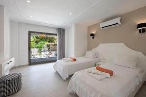 a hotel room with two beds and a window at Charming 3bed villa w/ pool, very close to centre in Kas +40 photos