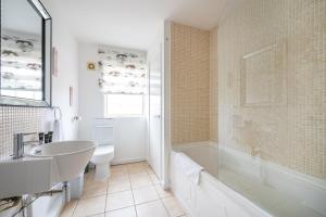 een badkamer met een bad, een wastafel en een toilet bij RB27R For your most relaxed & Cosy stay Free Parking Free Fast WiFi in Kirkstall