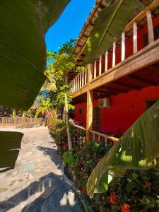 un resort con un edificio rosso e alcuni fiori di Super Flats Geribá a Búzios