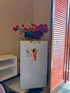 a bowl of flowers on top of a refrigerator at Super Flats Geribá in Búzios