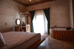 Schlafzimmer mit einem Bett und einer Badewanne in der Unterkunft Matiana View Cave Hotel in Goreme