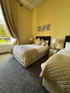 a bedroom with two beds and a window at Morehampton Townhouse in Dublin