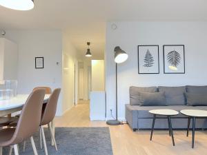 a living room with a couch and a table and chairs at Bright And Spacious 3 Bedroom Apt In Orestaden in Copenhagen