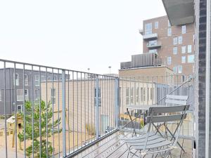 a balcony with two chairs and a table on it at Bright And Spacious 3 Bedroom Apt In Orestaden in Copenhagen