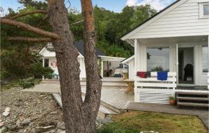 a white house with a porch and a tree at 4 Bedroom Cozy Home In Stavang in Stavang