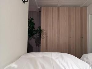 Appartement 412 Kunners Oostenrijk في ميتلبرغ: غرفة نوم بسرير ابيض وخزانات خشبية