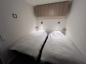 2 letti in una camera con pareti bianche di Appartement 412 Kunners Oostenrijk a Mittelberg