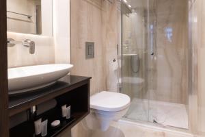 a bathroom with a sink and a toilet and a shower at Montcalm Chilworth Townhouse, Paddington in London