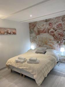 a bedroom with a large bed with roses on the wall at Esprit Romantique in Mulhouse