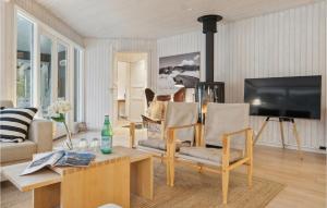 a living room with two chairs and a tv at Stunning Home In Nex With Kitchen in Vester Sømarken
