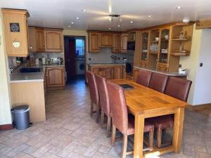 a kitchen with a wooden table and chairs at Bedlwyncoch Farmhouse in Brecon