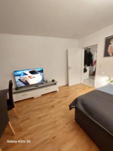 Schlafzimmer mit einem Flachbild-TV und einem Bett in der Unterkunft Appartement am Uni Park Köln Sülz in Köln