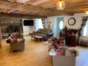 a living room with two couches and a fireplace at Bedlwyncoch Farmhouse in Brecon