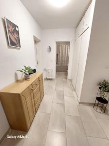 a hallway with white walls and a wooden dresser at Appartement am Uni Park Köln Sülz in Cologne