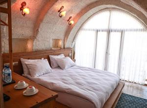 ein Schlafzimmer mit einem großen Bett und einem Holztisch in der Unterkunft Matiana View Cave Hotel in Goreme