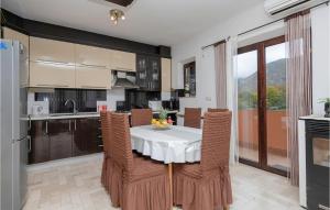 a kitchen and dining room with a table and chairs at Awesome Home In Mijaca With Kitchen 