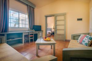 ein Wohnzimmer mit einem Sofa und einem Tisch in der Unterkunft Royal Suite in Costa Calma