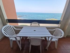 stół i krzesła na balkonie z widokiem na ocean w obiekcie 176 Indes Galantes G91 w Cap d'Agde