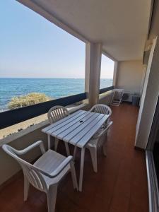 stół i krzesła na balkonie z widokiem na ocean w obiekcie 176 Indes Galantes G91 w Cap d'Agde