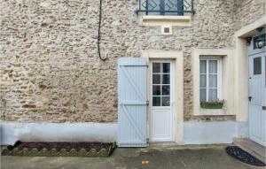 un antiguo edificio de piedra con puerta y ventana en Stunning Home In Champeaux With Kitchen, en Moisenay