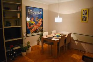 een eetkamer met een tafel met stoelen en een tv bij Apartman 23 in Kanarevo Brdo