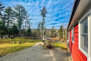 una casa roja con una valla al lado de un patio en Woodland Cottage In the Mountains, 