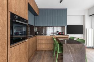 een keuken met houten kasten en groene stoelen bij Charming Bright 1bd Modern Pad Wparking #337 in Istanbul