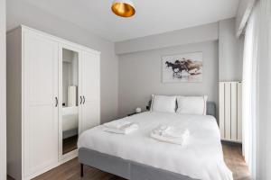 een witte slaapkamer met een wit bed en een spiegel bij Charming Bright 1bd Modern Pad Wparking #337 in Istanbul