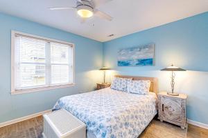 a bedroom with a bed and a ceiling fan at Dog Daze of Summer East in Emerald Isle