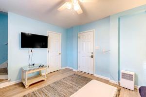 a living room with blue walls and a flat screen tv at Dog Daze of Summer East in Emerald Isle